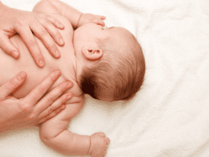 bébé sur le ventre et maman fait un massage