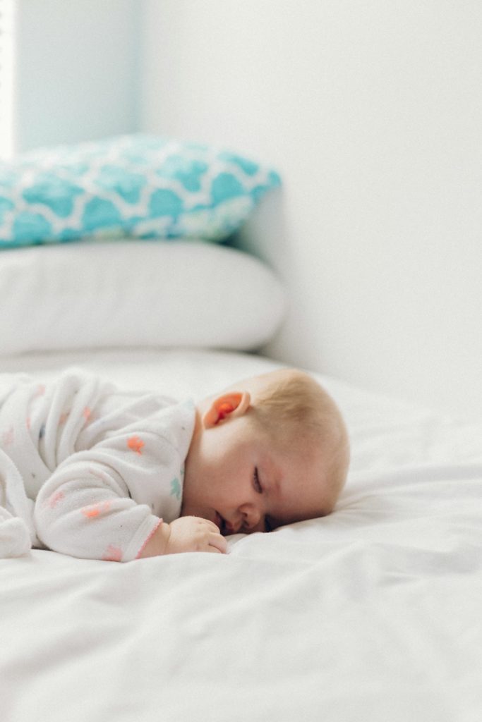 un bébé qui dort sur le ventre